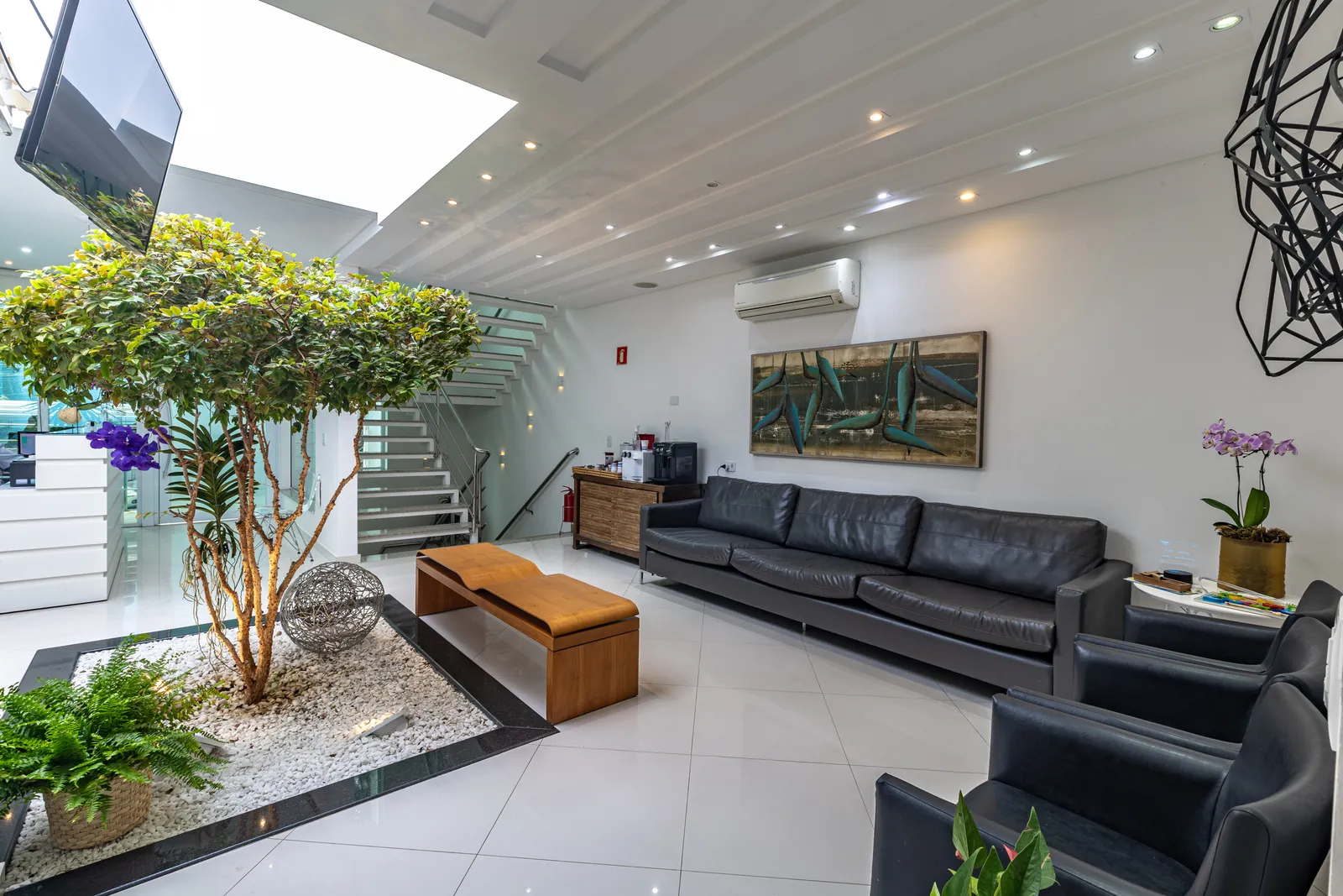 Sala de espera confortável com sofás e jardim interno